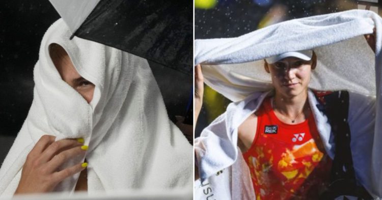 Aryna Sabalenka, left and Elena Rybakina, Right wrapped in towels on the court while waiting for the rain to stop